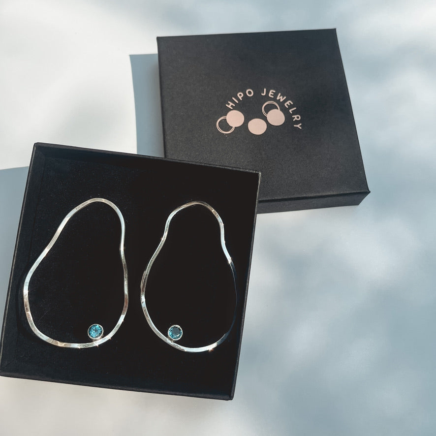 Asymmetric earrings with a splash of blue
